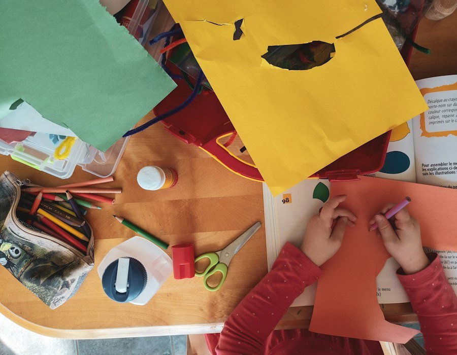 Children making things at a table covered with craft materials