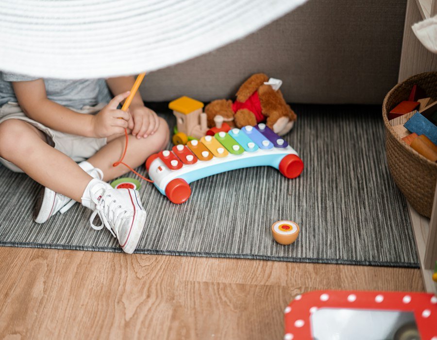 A child playing a xylophone on the floor