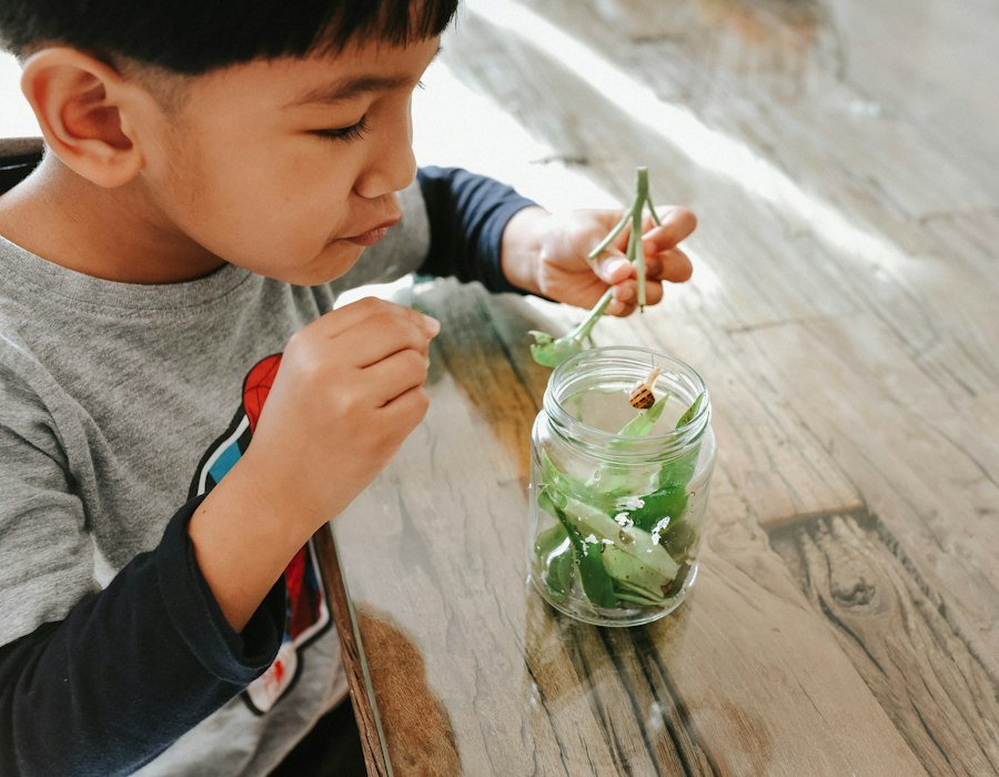 A child exploring with a jar of water at a table