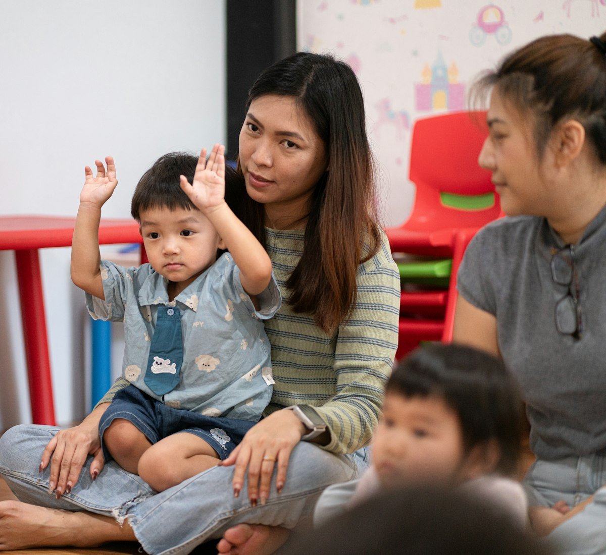 An adult and children together in a bright classroom