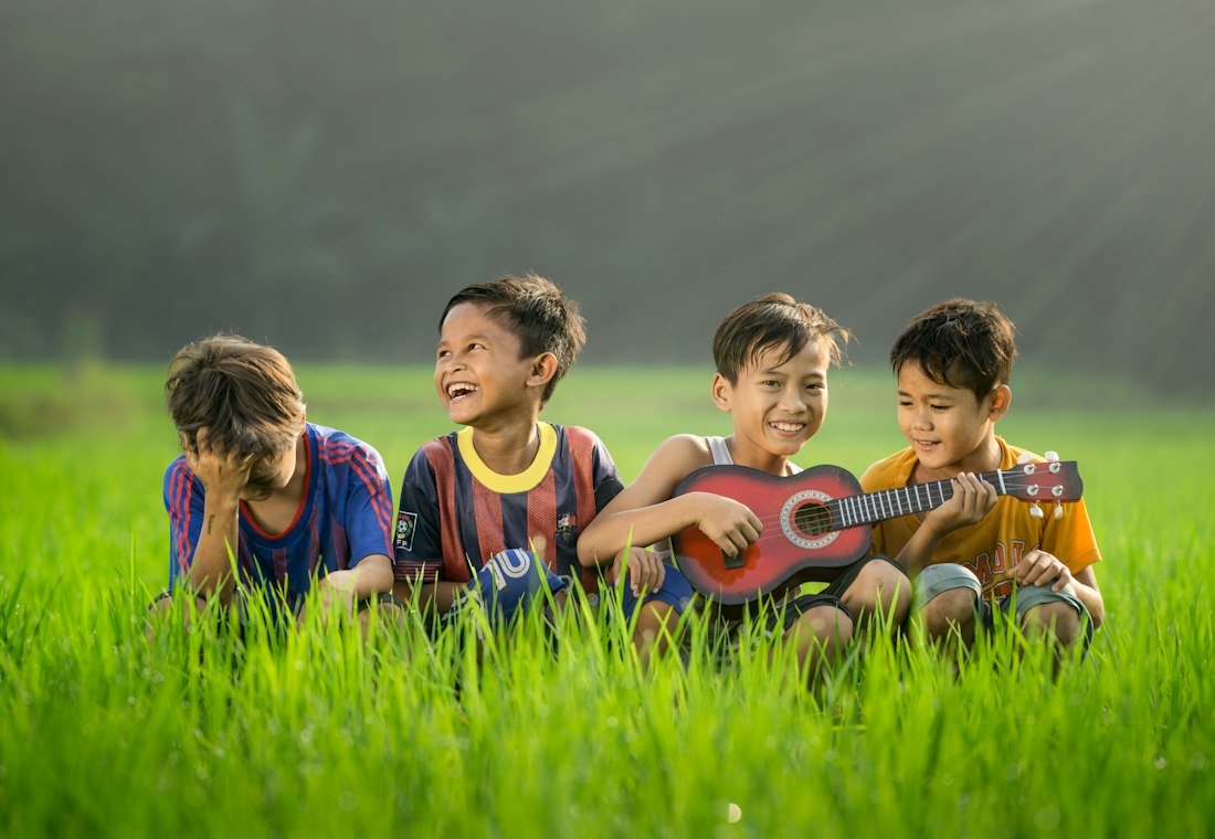 Children laughing together outdoors on the grass