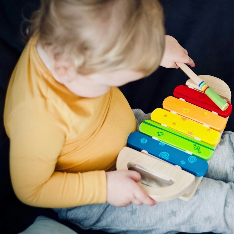 A child playing a rainbow xylophone