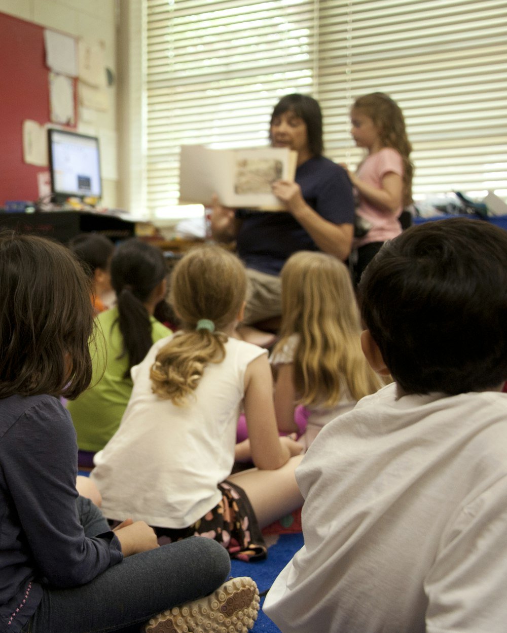 Children sitting together on a classroom floor during story time